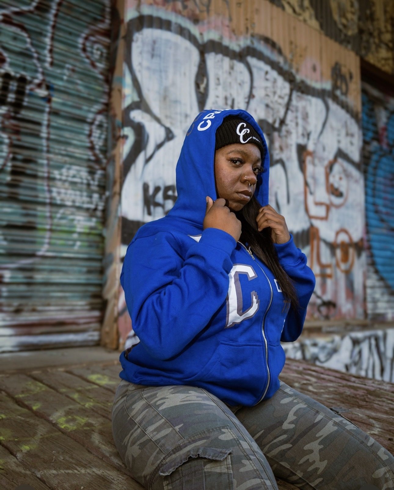 CENSORED CLOTHIN editorial — blue hooded zip-up and camo pants against graffiti